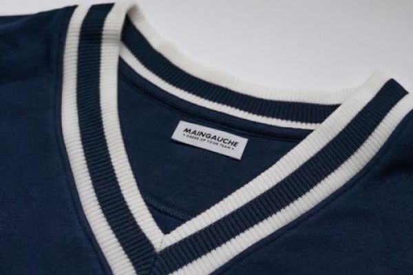 Etiquettes en polyester tissé avec écrit MAINGAUCHE sur pull à col V